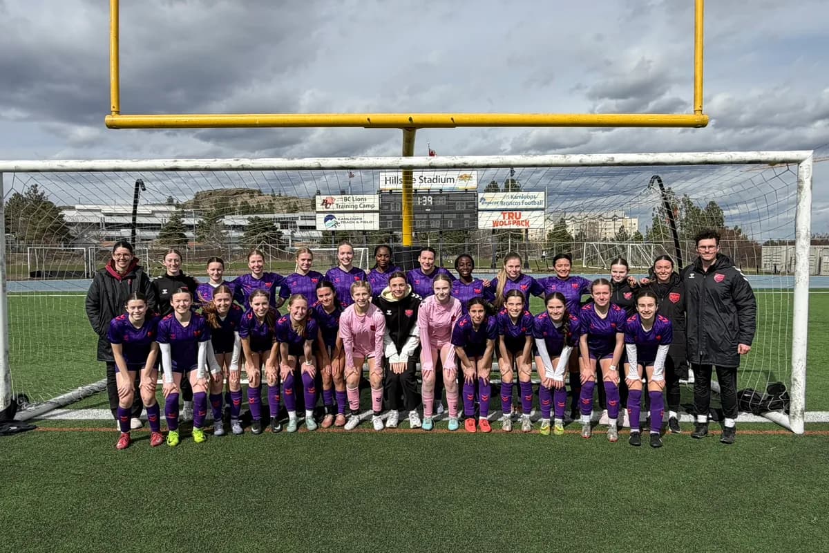 Wild Academy players and coaches posing together in front of a soccer goal.